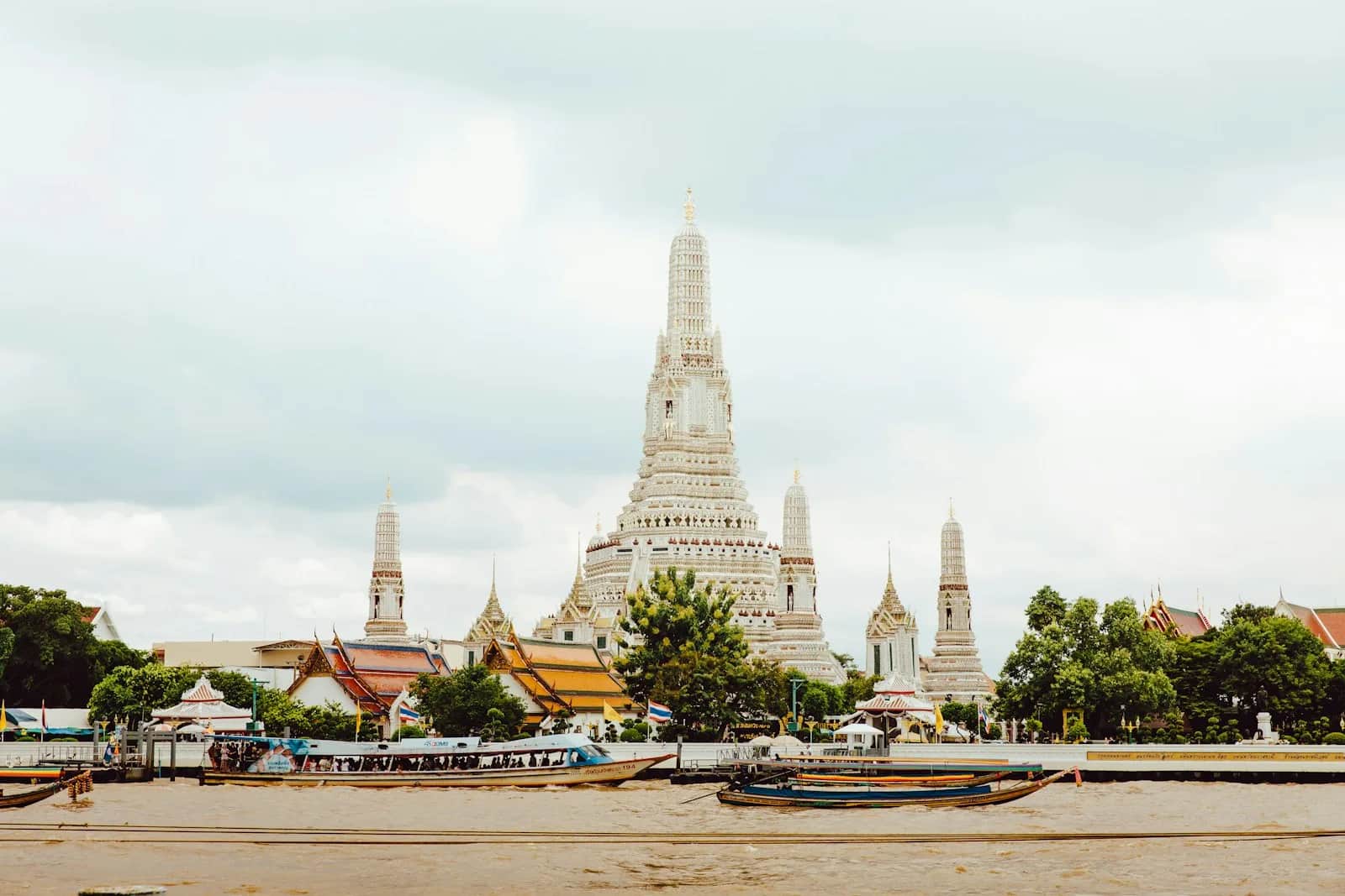 Boeddhistische tempel met sierlijke daken in Bangkok onder een bewolkte hemel