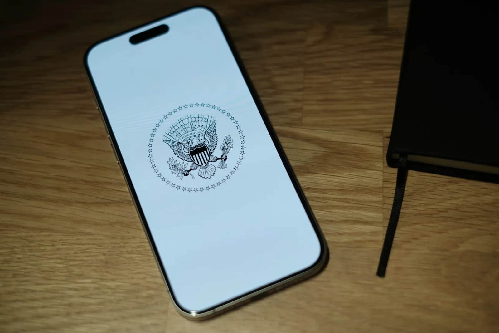 A white iPhone sitting on top of a wooden table
