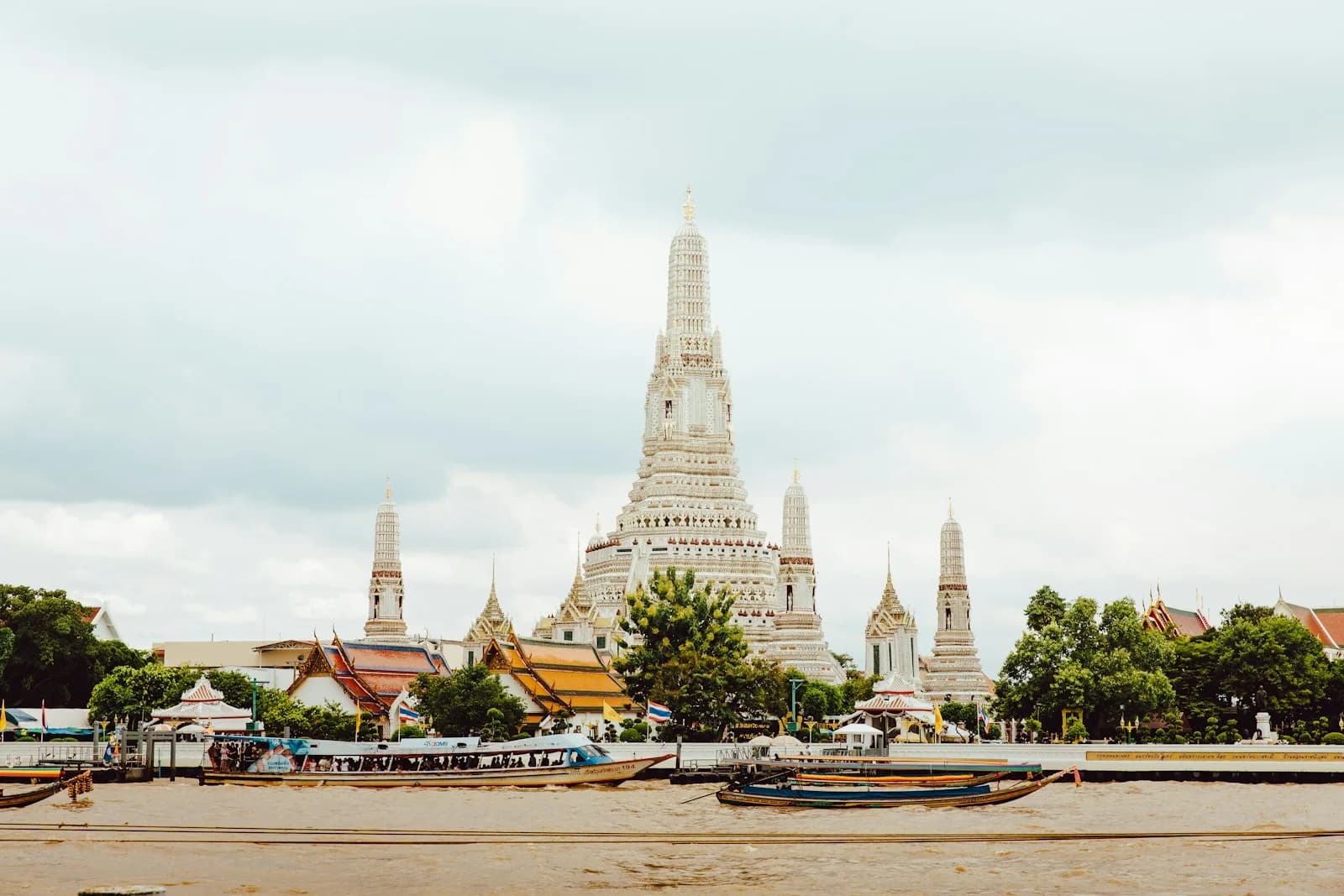 Boeddhistische tempel met sierlijke daken in Bangkok onder een bewolkte hemel