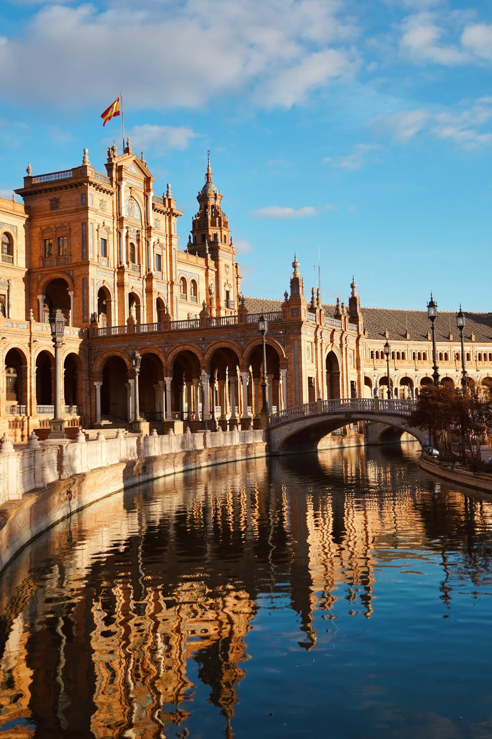 Plaza de España in Sevilla met sierlijke tegels en boogbruggen bij zonsondergang