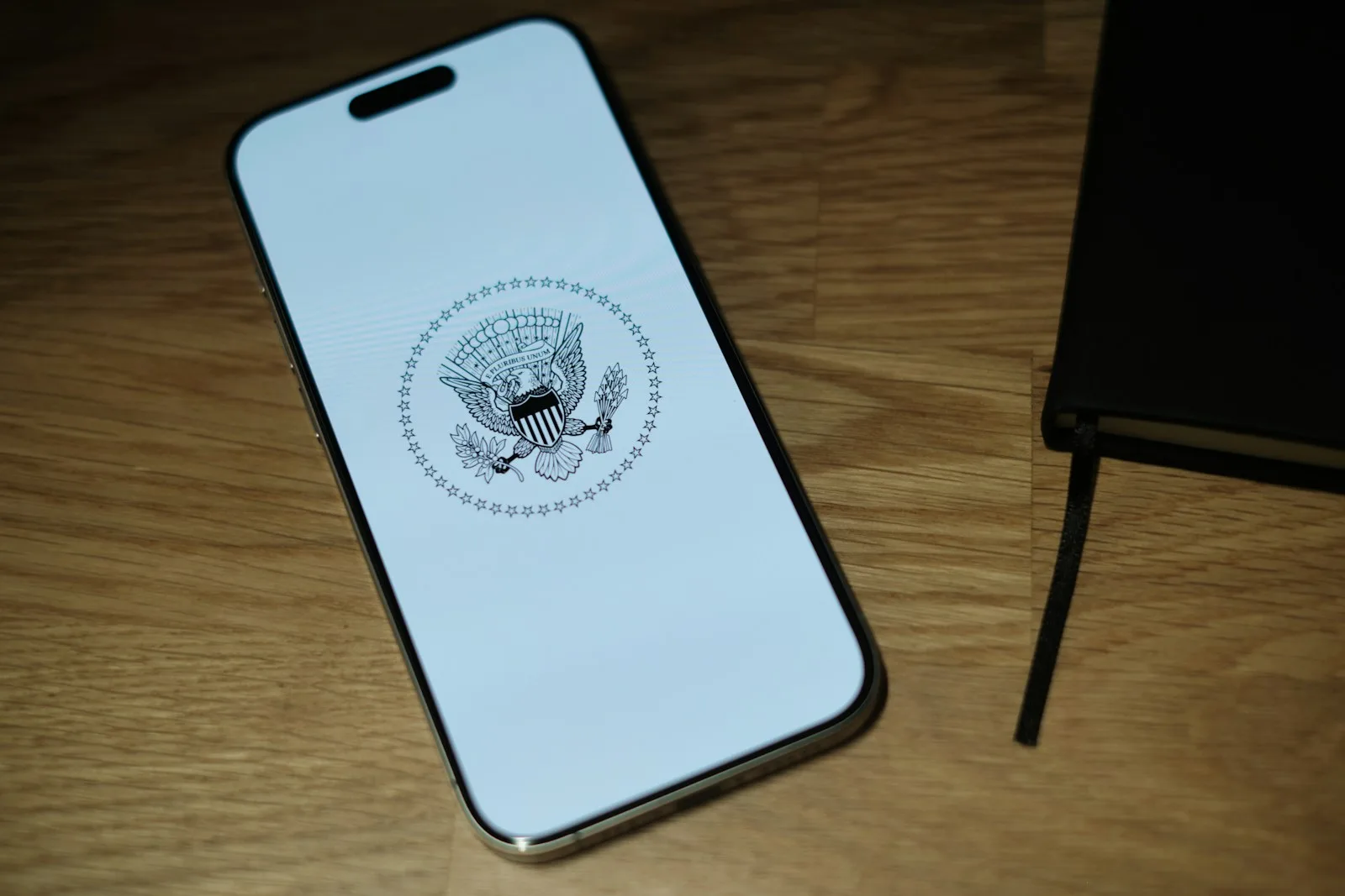 A white iPhone sitting on top of a wooden table